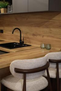 a kitchen with a counter with a sink and two chairs at Hotel and Coffee Bar Old Bazaar in Skopje +66 photos