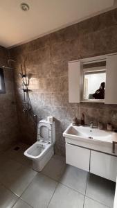 a bathroom with a toilet and a sink and a mirror at Havre de paix in Dakar