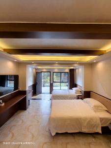 a bedroom with three beds and a large window at Cloud 9 Resort Hotel in Yangchang