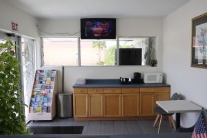 a kitchen with a counter with a microwave and a window at Crossroads Inn in Fort Pierce