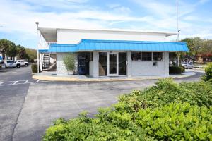 a store with a blue awning in a parking lot at Crossroads Inn in Fort Pierce
