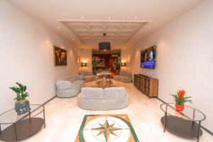a living room with two couches and a tv at Noah Gate Hotel & Suites in Naples