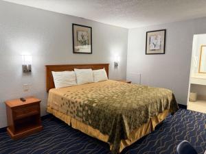 a hotel room with a bed and a table at Crossroads Inn in Fort Pierce +19 photos