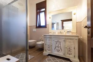 a bathroom with a sink and a toilet and a mirror at Domus Japigia in Ugento +29 photos