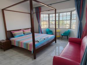 a bedroom with a canopy bed and a couch at Da Pink And White Palace in Nassau +41 photos