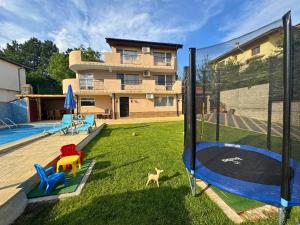 a house with a yard with a playground at Helena Guest House - Pool & Sea View in Balchik