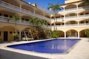 an exterior view of a building with a large swimming pool at We playa Hotel - Adults Only in Playa del Carmen