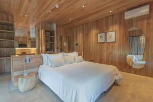 a bedroom with a large white bed and wooden walls at Locus Solus Hotel Singular in Mar del Plata +48 photos