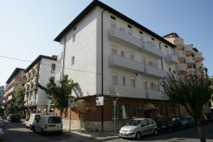 een gebouw waar auto's voor geparkeerd staan bij Hotel Villa Rosa in Grado