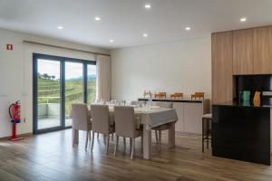 a kitchen and dining room with a table and chairs at Casa do Paçô - Cabeceiras de Basto in Cabeceiras de Basto