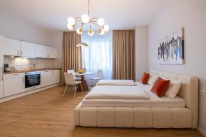 a white bedroom with a large bed and a kitchen at Altstadt City Loft in Würzburg