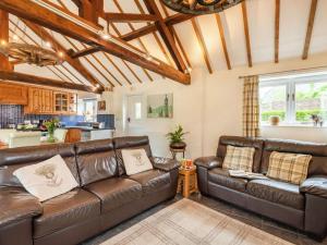 a living room with a leather couch and a kitchen at 3 Bed in Wareham oc-dc129 in Turners Puddle
