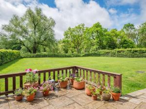 a bunch of potted plants on a wooden fence at 3 Bed in Wareham oc-dc129 in Turners Puddle