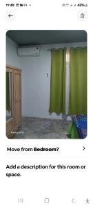a room with a green curtain and a door at Appartement Le Cap in Cap Malheureux