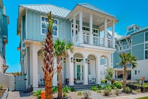 a large house with a large porch and palm trees at Palmilla Beach Sunrise Dreams in Port Aransas