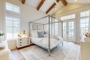a bedroom with a canopy bed in a room with windows at Palmilla Beach Sunrise Dreams in Port Aransas