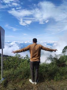 a man standing on top of a hill with his arms outstretched at Via Tayrona in Santa Marta