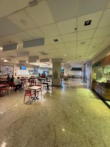 a cafeteria with tables and chairs in a building at Jam flats beira mar Olinda in Olinda