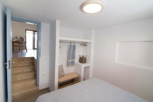 a white bedroom with a bed and a hallway at Villa Yvon Telendos - Villa # 1 in Telendos