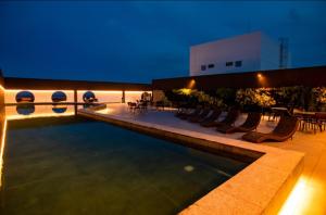 a pool on the roof of a building at night at Jam flats beira mar Olinda in Olinda