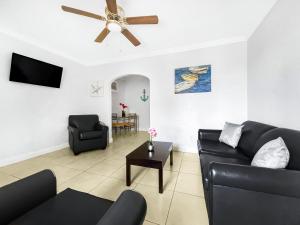 a living room with a couch and a ceiling fan at Hollywood Broadwalk Oceanside Hotel in Hollywood