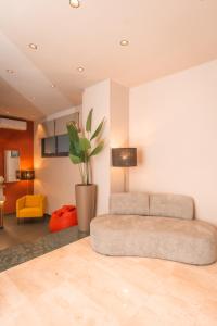a living room with a couch and a potted plant at Noah Gate Hotel & Suites in Naples