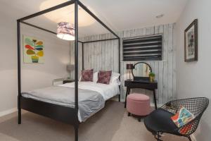 a bedroom with a canopy bed with a desk and a chair at Lancaster City Apartment in Lancaster