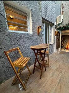 a wooden table and a chair on a patio at Aloha Guest House in Fortaleza