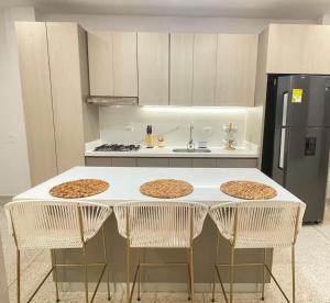 a kitchen with a table with four chairs and a refrigerator at Apartahotel MONACO in Ginebra