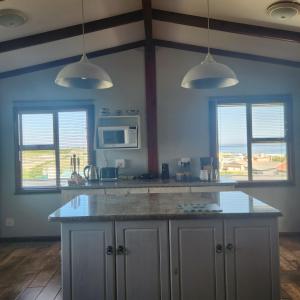 a kitchen with a counter top and two windows at 51onStirling in De Kelders