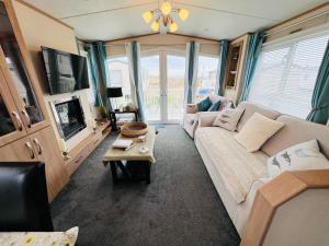 a living room with a white couch and a tv at Celebration by the sea in Redcar