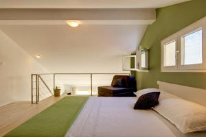 een slaapkamer met een groot bed en een stoel bij Apartments Lianto in Drasnice