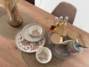 a table with plates and bowls on a table at Ecrin de Lin in Rosnoën