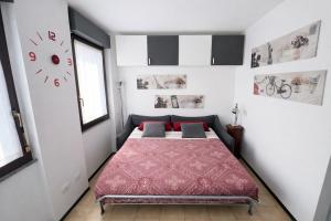 a bedroom with a bed and a clock on the wall at Bella Vita Stays Cozy in Sondrio