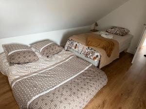 two beds sitting next to each other in a room at Ecrin de Lin in Rosnoën