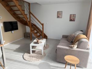 a living room with a couch and a table at Ecrin de Lin in Rosnoën