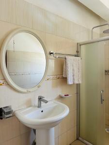 a bathroom with a sink and a mirror and a shower at Hidden beautiful Modern Apartment in Entebbe +103 photos