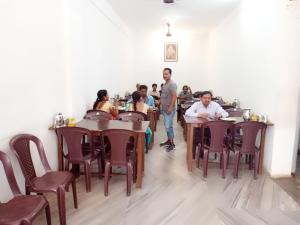 a group of people sitting at tables in a restaurant at Hotel Sanskar in Pachmarhī