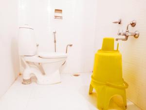 a bathroom with a toilet and a yellow object at Hotel Sanskar in Pachmarhī