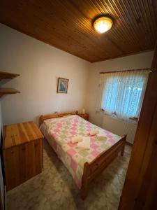 a bedroom with a bed and a wooden ceiling at Pansedon House by the sea in Nea Kallikrateia