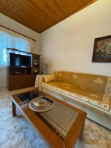 a living room with a couch and a coffee table at Pansedon House by the sea in Nea Kallikrateia