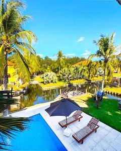 a pool with two chairs and a umbrella next to a resort at Venecia Yatch Club in San Luis La Herradura