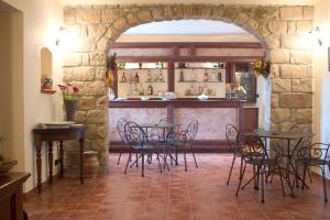 ポリッツィ・ジェネローザにあるIl Baglio di Nonna Cleliaのテーブルと椅子のあるレストランのアーチ道