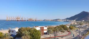 a view of a beach with a boat in the water at Coral Bay Suite Hotel in Khor Fakkan