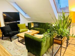 a living room with a green couch and a table at Studio apartman in Kőszeg