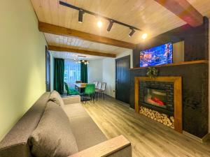 a living room with a couch and a fireplace at Шале in Krivopolʼye