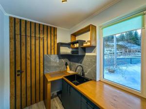 a kitchen with a sink and a large window at Шале in Krivopolʼye