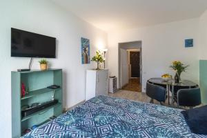 a bedroom with a bed and a table and a television at Super Menton Bord Mer in Menton