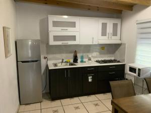 a kitchen with a stainless steel refrigerator and a sink at Cozy 2BR Cabin with Pool in Cabo Rojo in Cabo Rojo