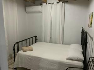 a bed in a room with a white curtain at Cozy 2BR Cabin with Pool in Cabo Rojo in Cabo Rojo +17 photos